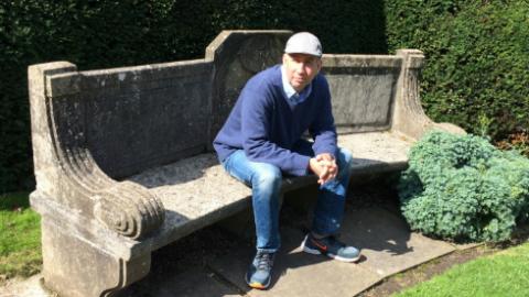 Image shows blogger Trevor sat on a garden bench on a sunny day