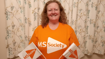 Sharon in an MS Society tshirt with MS Society branded flags