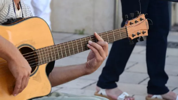 a photo of a man playing the Guitar outside