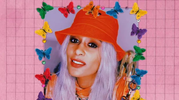 Image shows Roxanne wearing a red hat with an illustrated frame over her image of butterflies in different colours of the rainbow, over a pink background.