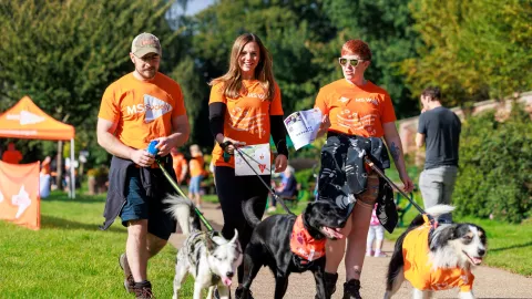 Three people with dogs participating in an event